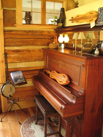 Piano and dulcimer at Snug Hollow Appalachian instruments and antiques decorate Snug Hollow.