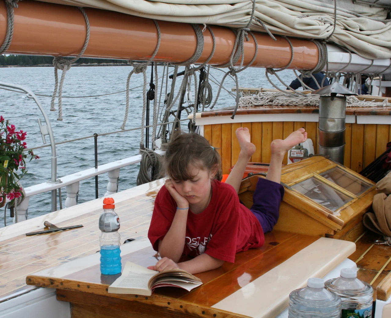 Girl reading on a Maine schooner ©Laurel Kallenbach