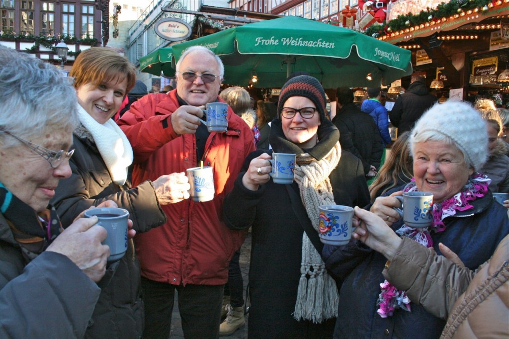 Visitors share a steamy mug of glühwein at the Frankfurt Christmas Market. The toast concludes the “Stories, Sweets, and Savories” guided tour. ©Laurel Kallenbach