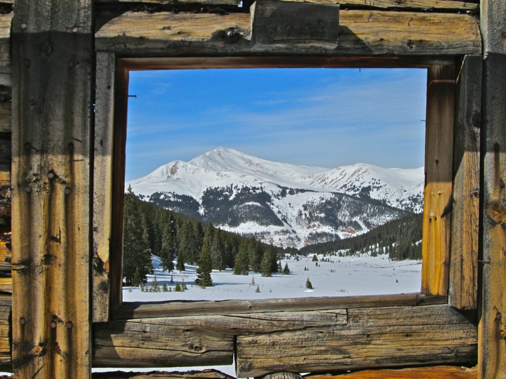 The window of a century-old miner’s cabin frames a peak in Mayflower Gulch, near the Copper Mountain ski area in Colorado’s Rocky Mountains. ©Ken Aikin