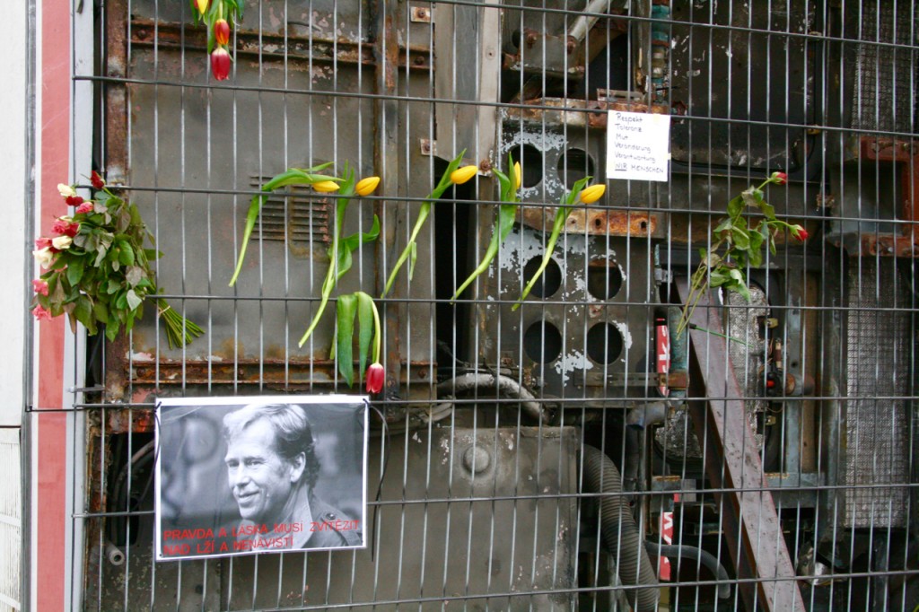 Flowers and notes are attached to the grillwork on the underbelly of the buses. The note says, "Respect, Tolerance, Courage, Change, Responsibility, We Are Humans ©Laurel Kallenbach